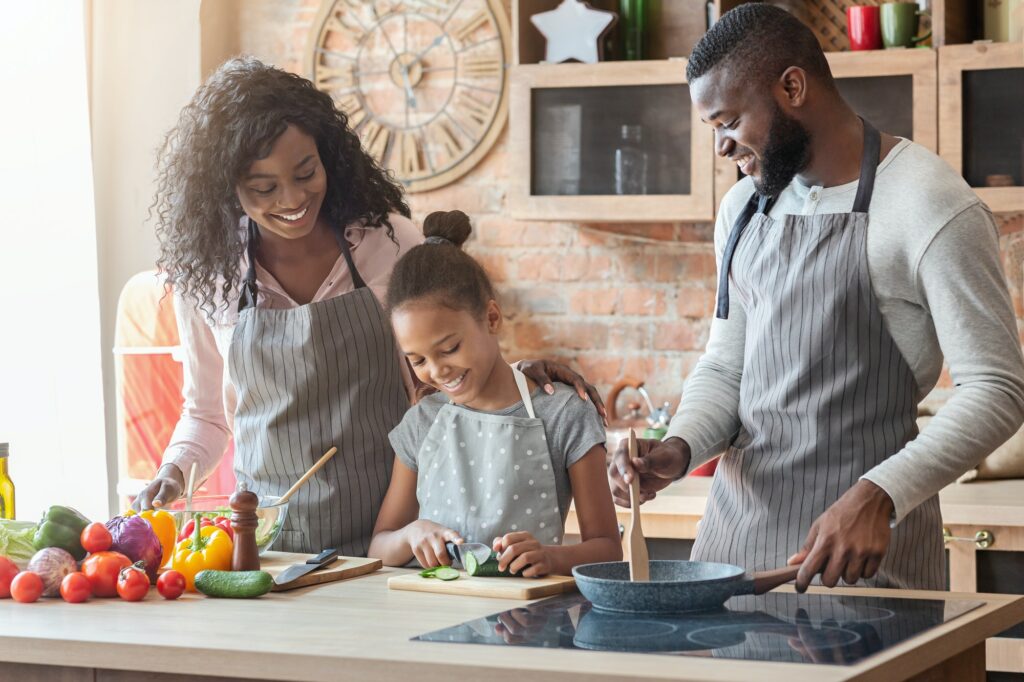 Girl making her first meal, spending time together with parents